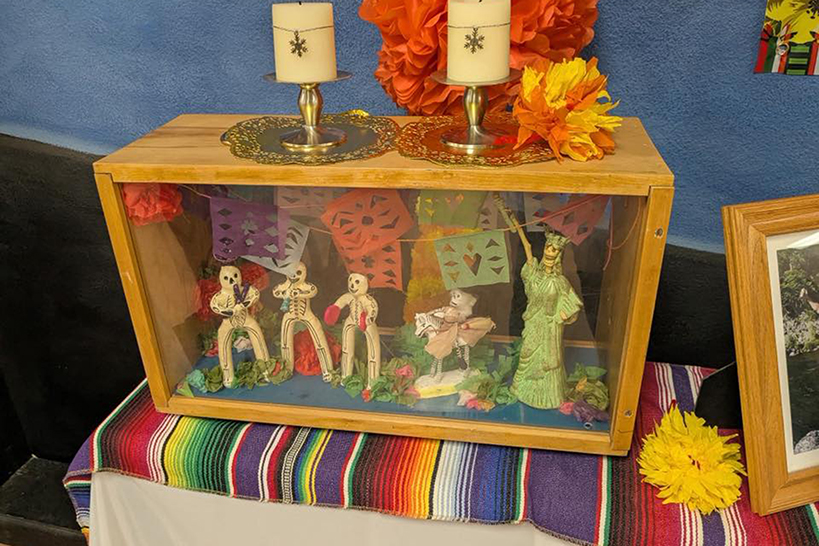 A wooden box displaying a Dia de los Muertos celebration