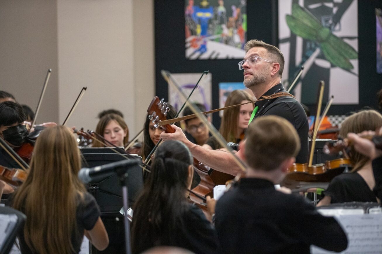 The Gridley band director plays guitar while his students perform at the Governing Board meeting